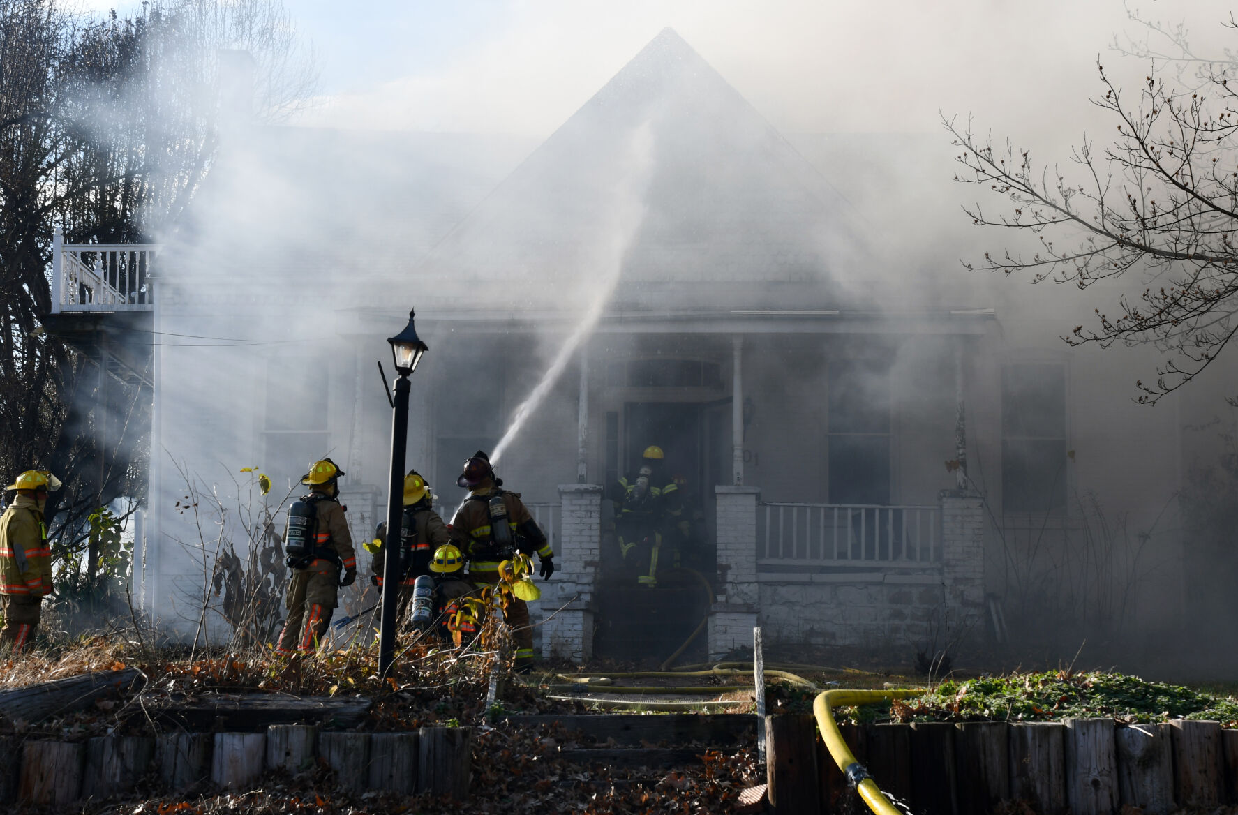 Firefighters hose down a burning home